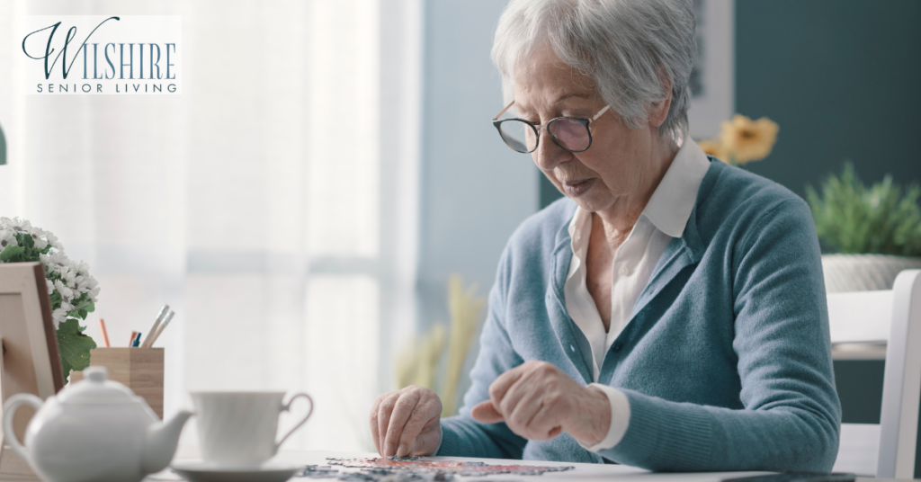 Benefits of memory care. A senior woman sitting at the desk and solving a puzzle.