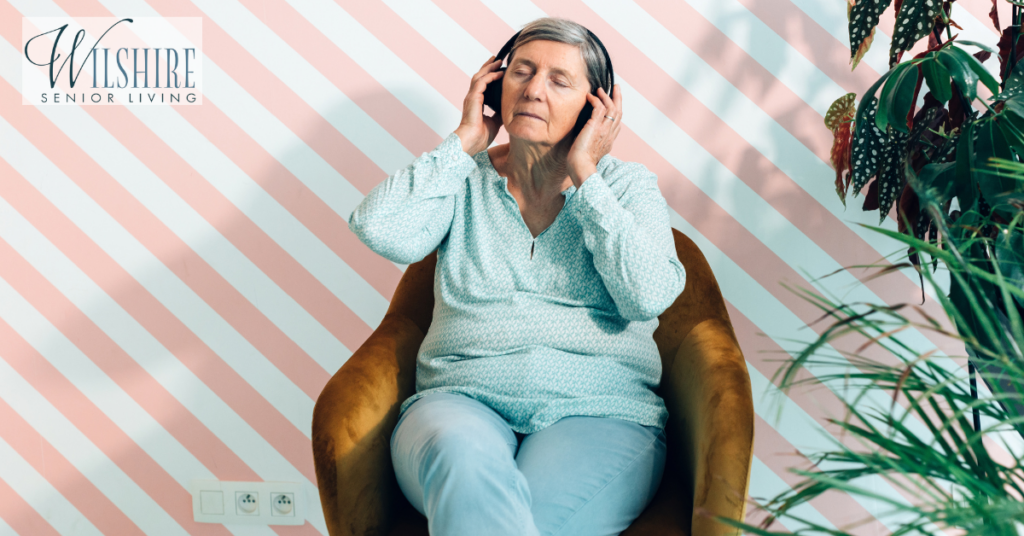 A senior old lady sitting in a comfortable chair listening to music. Music therapy for dementia​.